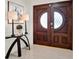 Elegant wooden double doors with glass inlays and decorative lamps on a glass top table at 4309 Deepwater Ln, Tampa, FL 33615