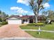 Charming single-story home featuring a manicured lawn and beautiful brick driveway at 4309 Deepwater Ln, Tampa, FL 33615