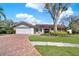 Charming single-story home featuring a manicured lawn and beautiful brick driveway at 4309 Deepwater Ln, Tampa, FL 33615