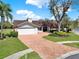 Charming single-story home featuring a manicured lawn and beautiful brick driveway at 4309 Deepwater Ln, Tampa, FL 33615