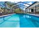 Sparkling pool in screened enclosure with inviting blue tile and lush landscaping at 4309 Deepwater Ln, Tampa, FL 33615