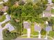 An aerial view of a home with mature trees, lush greenery, and a spacious yard at 5147 Elwood Rd, Spring Hill, FL 34608