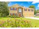 Beautiful two-story home with a well-manicured lawn and colorful flower beds at 5147 Elwood Rd, Spring Hill, FL 34608