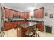 Kitchen with dark wood cabinets, granite countertops and island with seating at 5147 Elwood Rd, Spring Hill, FL 34608