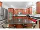 Kitchen with dark wood cabinets, granite countertops, stainless appliances and kitchen island at 5147 Elwood Rd, Spring Hill, FL 34608