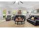 Spacious living room featuring an abundance of natural light, neutral carpet, and black leather seating arrangements at 5147 Elwood Rd, Spring Hill, FL 34608