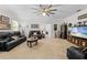 Spacious living room featuring an abundance of natural light, neutral carpet, and black leather seating arrangements at 5147 Elwood Rd, Spring Hill, FL 34608