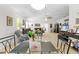 Open concept living room with tile floors, neutral colors, a dining space, and an abundance of natural light at 5147 Elwood Rd, Spring Hill, FL 34608