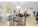 Cozy living room with neutral colors, tile floors, glass-top dining table, and view to the outdoor screened space at 5147 Elwood Rd, Spring Hill, FL 34608