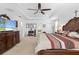 Spacious main bedroom featuring a ceiling fan, tray ceiling, carpet and a large dresser with TV at 5147 Elwood Rd, Spring Hill, FL 34608