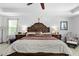 Large main bedroom with a tray ceiling, ceiling fan, and a decorative wood headboard at 5147 Elwood Rd, Spring Hill, FL 34608