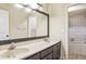 Bathroom with a double sink vanity, a large mirror, and tiled shower at 5202 Cumberland Dr, Tampa, FL 33617