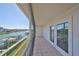 Screened condo balcony with tiled floor and a view of the canal and boat docks through double glass doors at 521 Pinellas Bayway S # 104, St Petersburg, FL 33715