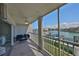 Screened condo balcony furnished with sofa and chairs overlooking the canal and boat docks at 521 Pinellas Bayway S # 104, St Petersburg, FL 33715