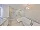 Stunning bathroom featuring a soaking tub, glass-enclosed shower, and elegant light fixture at 521 Pinellas Bayway S # 104, St Petersburg, FL 33715