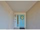 Front entryway with a light blue door, transom window, and floral wreath at 521 Pinellas Bayway S # 104, St Petersburg, FL 33715