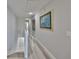 Hallway with stairs, artwork, and closet doors to the bedrooms at 521 Pinellas Bayway S # 104, St Petersburg, FL 33715