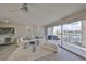 Living room with sleek white furniture, modern art and sliding glass doors leading to a balcony at 521 Pinellas Bayway S # 104, St Petersburg, FL 33715