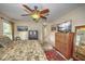 Relaxing bedroom with a ceiling fan, palm patterned comforter, and natural light from the window at 5327 N Cranberry Blvd, North Port, FL 34286