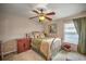 Comfortable bedroom featuring a ceiling fan, soft lighting, and a view of the window at 5327 N Cranberry Blvd, North Port, FL 34286