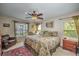 Comfortable bedroom featuring a patterned bedspread, ceiling fan, and views of the lush backyard at 5327 N Cranberry Blvd, North Port, FL 34286