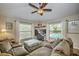 Inviting living room featuring a plush sectional, ceiling fan, and views of the outdoor pool at 5327 N Cranberry Blvd, North Port, FL 34286