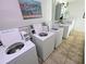 Community laundry room featuring multiple white washers and dryers at 5973 Terrace Park N Dr # 301, St Petersburg, FL 33709