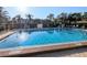 Community pool with clear blue water, lounge chairs, and handicap lift at 5973 Terrace Park N Dr # 301, St Petersburg, FL 33709