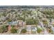 A wide aerial view exhibits the neighborhood, highlighting the property's location among lush greenery and other homes at 6303 Central Ave, New Port Richey, FL 34653