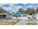 Beautifully renovated home showcasing modern colors and landscaping, surrounded by a white picket fence at 6303 Central Ave, New Port Richey, FL 34653