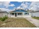 Charming single-story home featuring a well-manicured front lawn and eye-catching blue and white exterior at 6303 Central Ave, New Port Richey, FL 34653