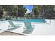 Outdoor community pool is surrounded by lounge chairs and lush landscaping at 700 Starkey Rd # 914, Largo, FL 33771