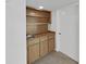 A quaint wet bar featuring wood cabinets, shelves, and a stainless steel sink adds convenience and charm at 700 Starkey Rd # 914, Largo, FL 33771