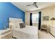 Comfortable bedroom with blue accent wall, ceiling fan, and a white comforter at 7115 Marsh View Ter, Bradenton, FL 34212