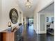 Elegant hallway with dark wood floors, chandelier lighting, artwork, and access to other rooms at 7115 Marsh View Ter, Bradenton, FL 34212