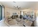 The open-concept living room features a gray leather sectional, large windows, and modern ceiling fan at 7115 Marsh View Ter, Bradenton, FL 34212