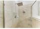 Walk-in shower featuring beige tile, a shower head and glass shelving at 7115 Marsh View Ter, Bradenton, FL 34212