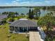 Aerial view of home showcasing a spacious yard, mature trees, and lake views at 7609 Clair Wood Ct, Apollo Beach, FL 33572