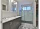 Modern bathroom with double sink vanity, herringbone tile shower, and decorative black and white hexagon tile flooring at 7609 Clair Wood Ct, Apollo Beach, FL 33572