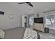 Bright bedroom features wood-look flooring, neutral walls, ceiling fan, and TV on a dresser with a view to the outside at 7609 Clair Wood Ct, Apollo Beach, FL 33572