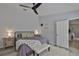 A modern bedroom with gray flooring, ceiling fan, accent rug, night stands, and a walk-in closet at 7609 Clair Wood Ct, Apollo Beach, FL 33572