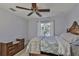 Bedroom features a ceiling fan, wooden bed frame, light walls, wood-look floors, and a window at 7609 Clair Wood Ct, Apollo Beach, FL 33572