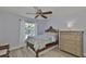 Bedroom features a ceiling fan, wooden bed frame, light walls, and wood-look floors at 7609 Clair Wood Ct, Apollo Beach, FL 33572