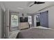 This bedroom features wood-look flooring, neutral walls, ceiling fan, a TV on a dresser, and a sliding barn door at 7609 Clair Wood Ct, Apollo Beach, FL 33572