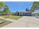 Charming single-story home with a well-manicured lawn, palm trees, and a two-car garage at 7609 Clair Wood Ct, Apollo Beach, FL 33572