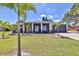 Beautiful single-story home with a well-manicured lawn and mature landscaping, enhanced by palm trees at 7609 Clair Wood Ct, Apollo Beach, FL 33572