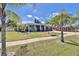 Landscaped front yard with a well-manicured lawn, palm trees, and a charming single-story home at 7609 Clair Wood Ct, Apollo Beach, FL 33572