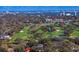 Aerial view showcasing a home nestled among trees near a golf course and a cityscape in the background at 1002 S Frankland Rd, Tampa, FL 33629
