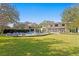 Spacious backyard features manicured lawn, mature trees, in-ground pool, outdoor kitchen, and firepit at 1002 S Frankland Rd, Tampa, FL 33629