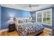 Calming blue bedroom with a tufted headboard, patterned bedding, and plantation shutters at 1002 S Frankland Rd, Tampa, FL 33629